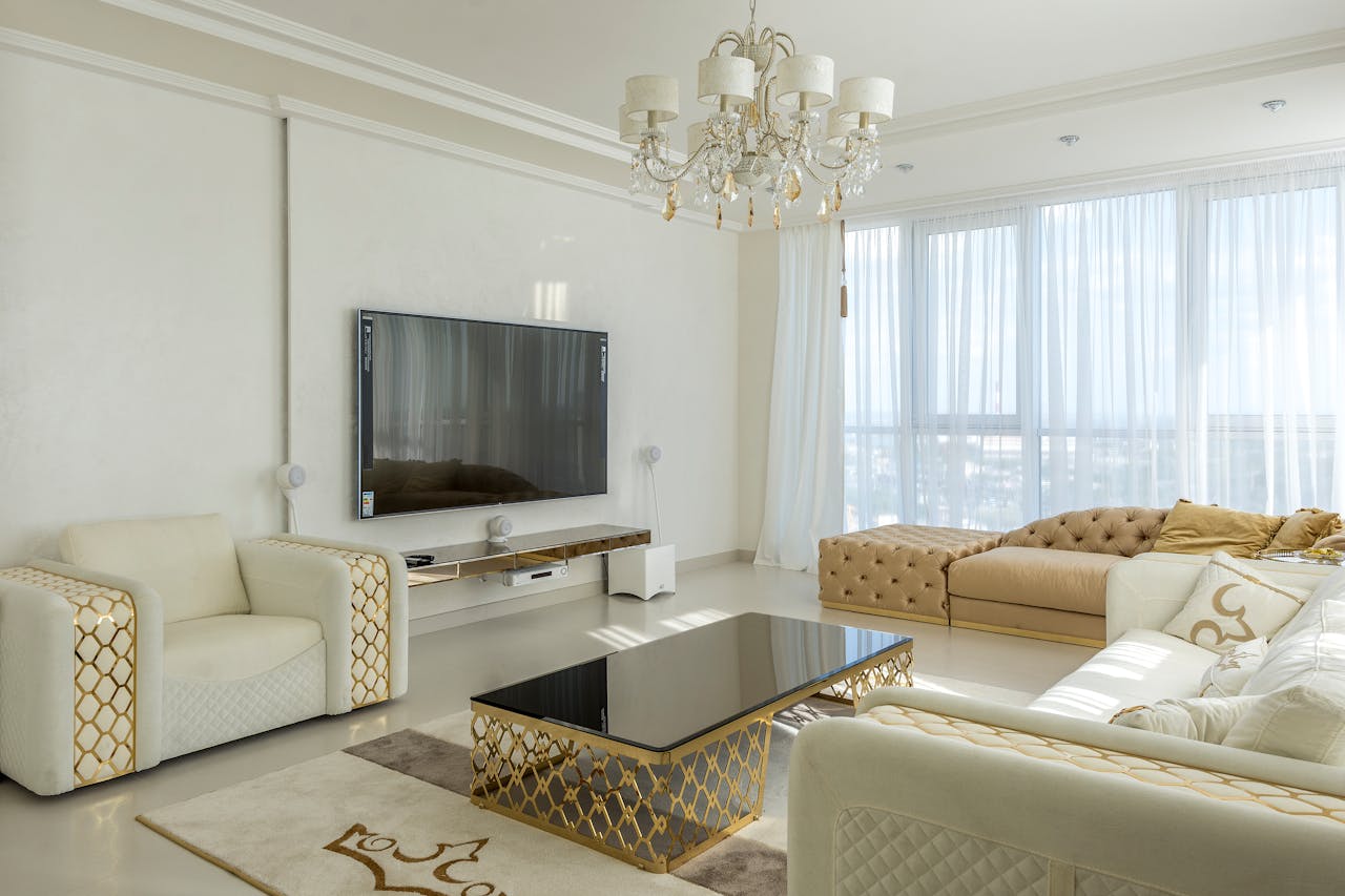 White and beige interior of modern comfortable living room with big sofas and armchair